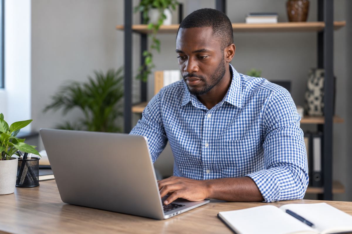 An administrator working at a laptop in an office